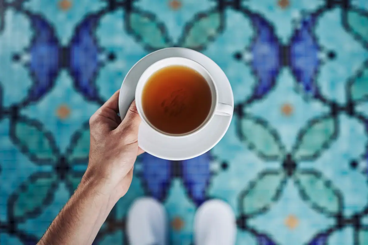 Eine Hand hält eine Teetasse.