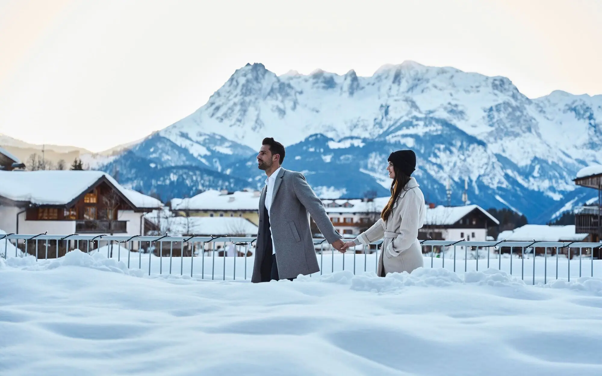 Winterurlaub in Werfenweng Ein Mann und eine Frau halten Hände im Schnee.