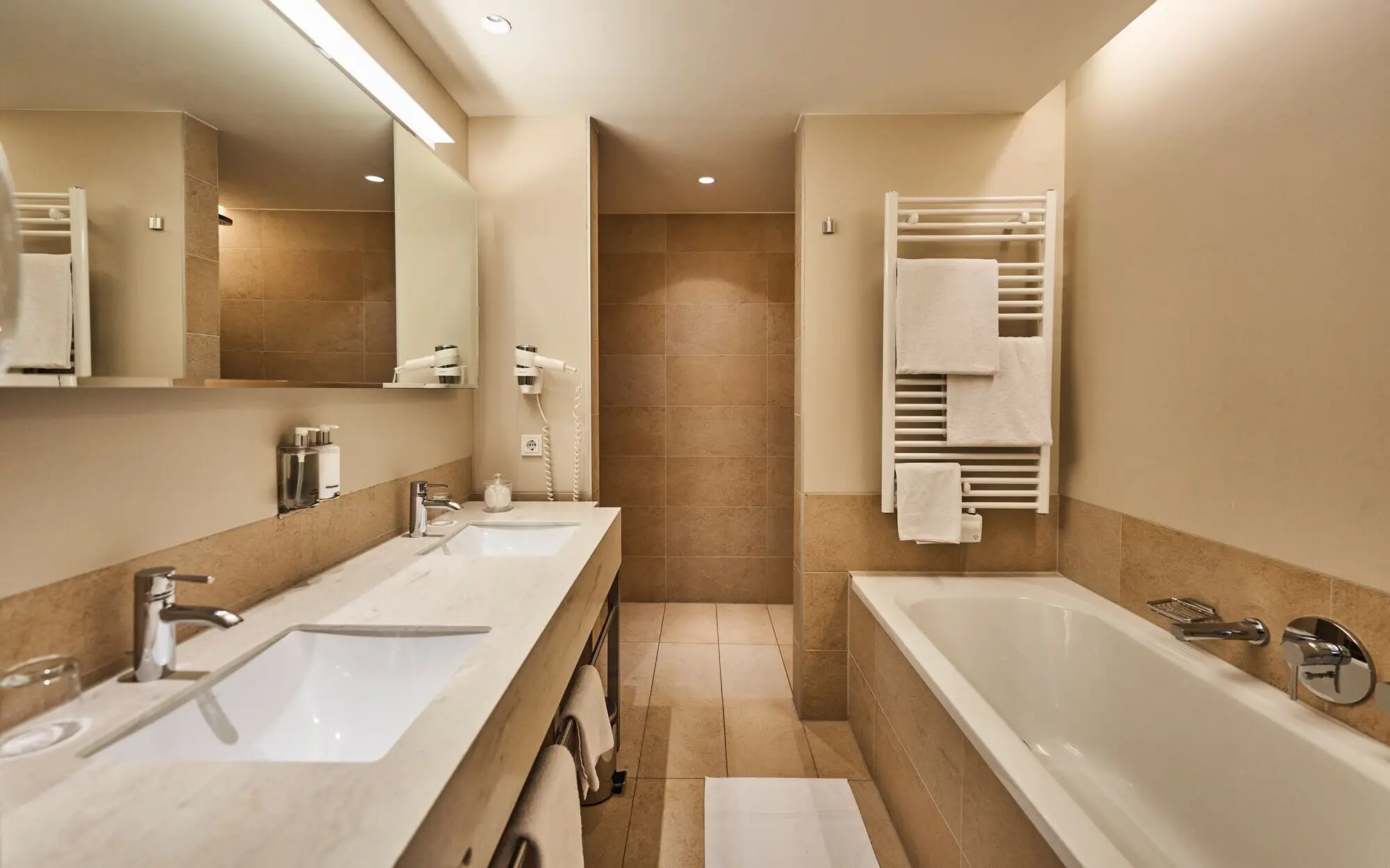 Badezimmer Suite Badezimmer mit Badewanne, Dusche und Waschbecken, gefliest und mit modernen Armaturen.