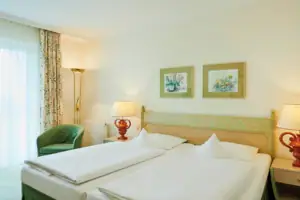 Doppelzimmer seeseitig Ein Zimmer mit zwei Betten und einer Lampe.