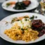 Essen und Trinken Ein Teller mit angerichteter Speise aus Spätzle, Gemüse und Fleisch in einer braunen Soße.