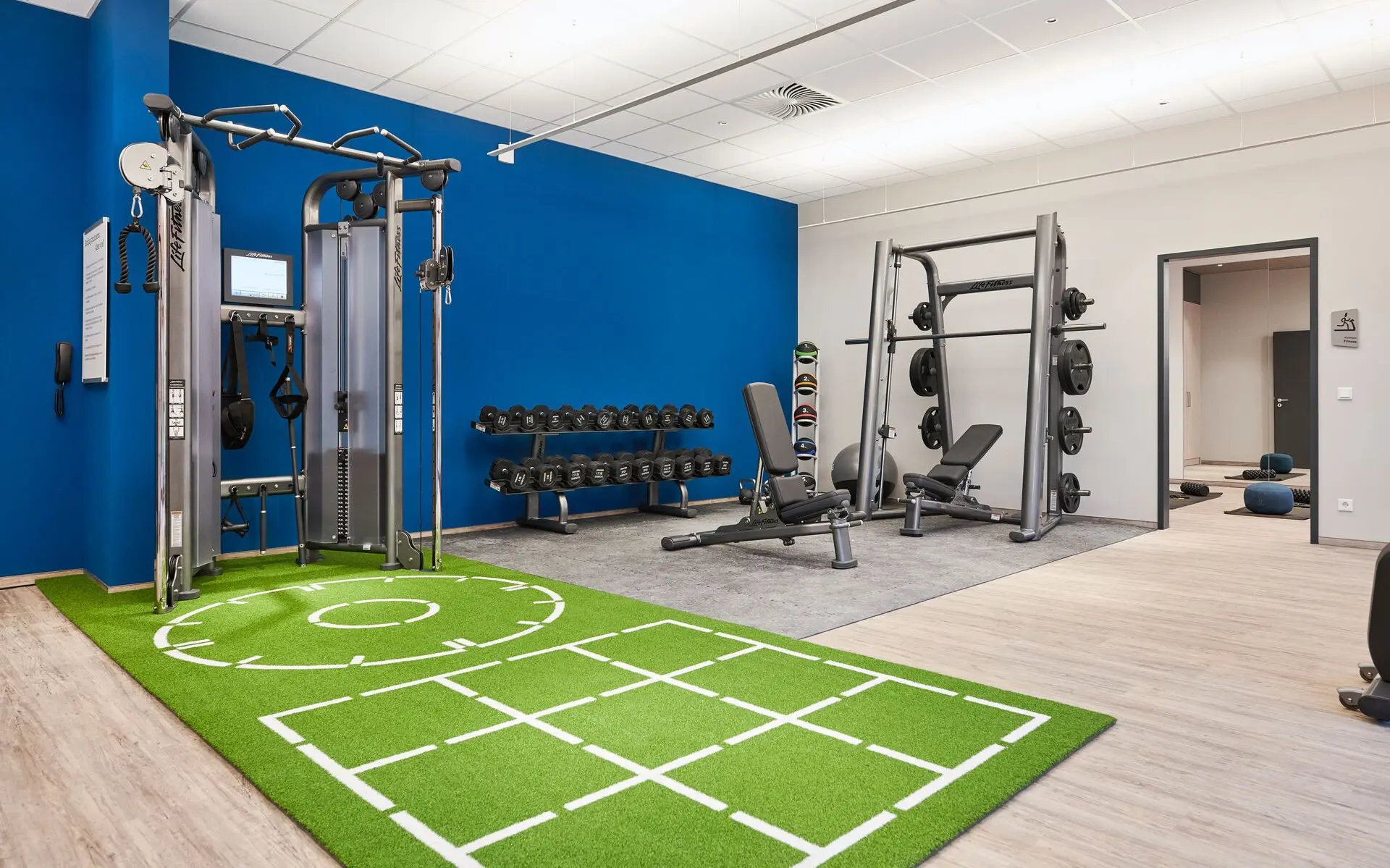 Ein Fitnessbereich mit Turm und Freihanteln.