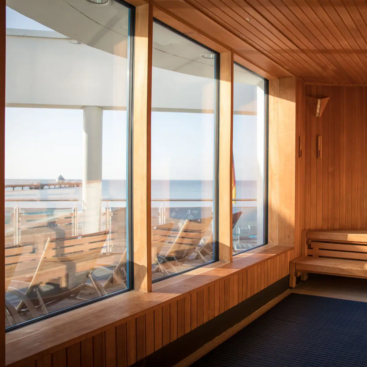 Sauna mit Meerblick Ein Raum mit Holzwänden und Fenstern.