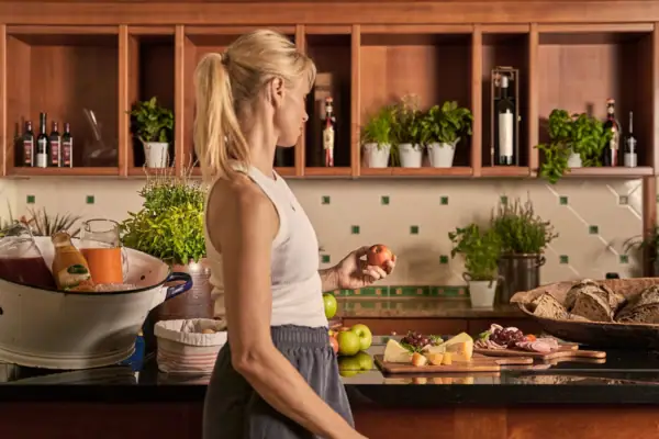 Frau hält einen Apfel in einer Küche