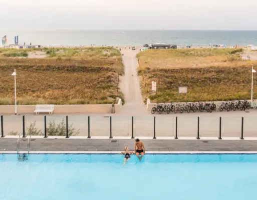 Außenpool im aja Warnemünde Ein Mann und ein Kind im Schwimmbecken.