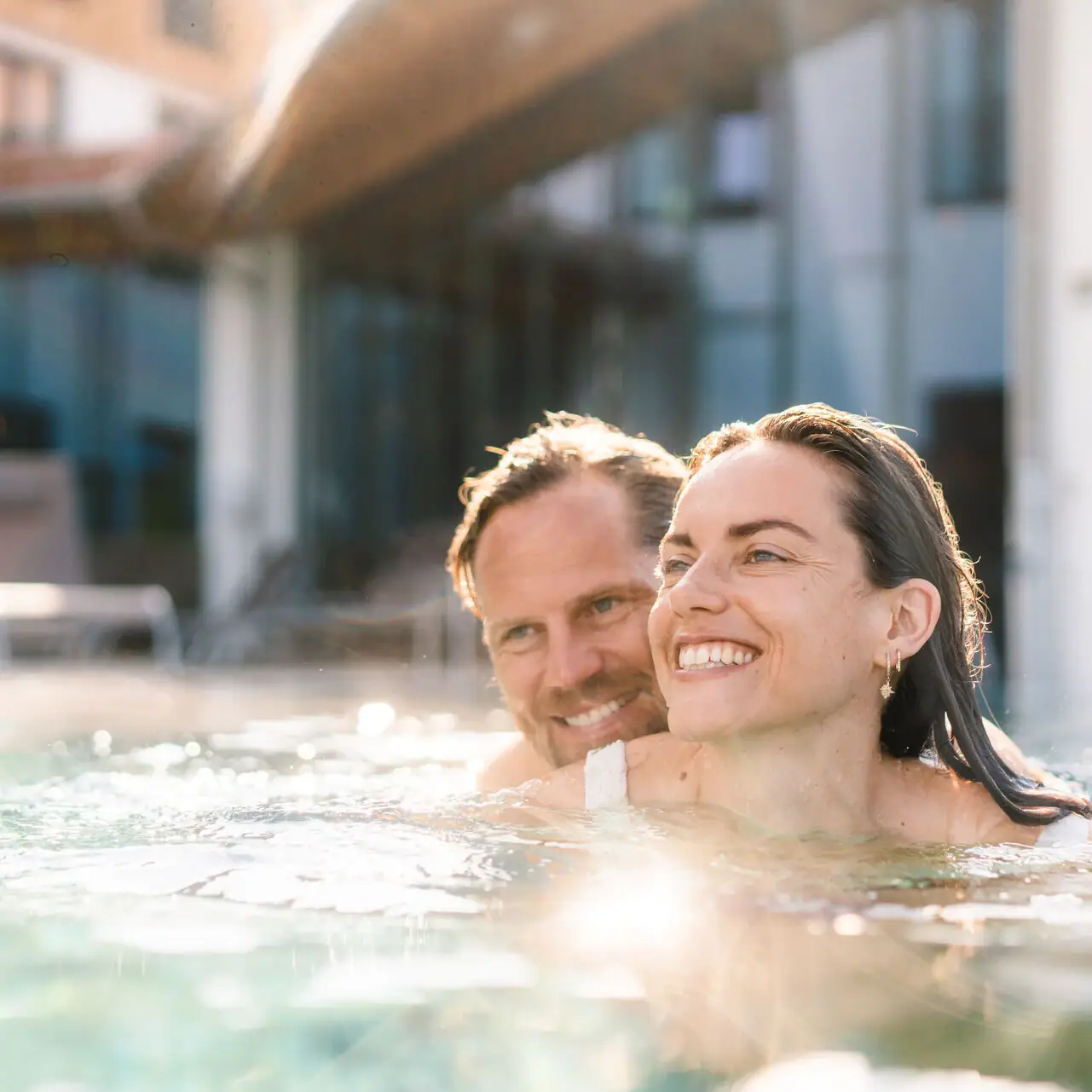 Day SPA in Ruhpolding Ein Mann und eine Frau lächelnd in einem Schwimmbecken.