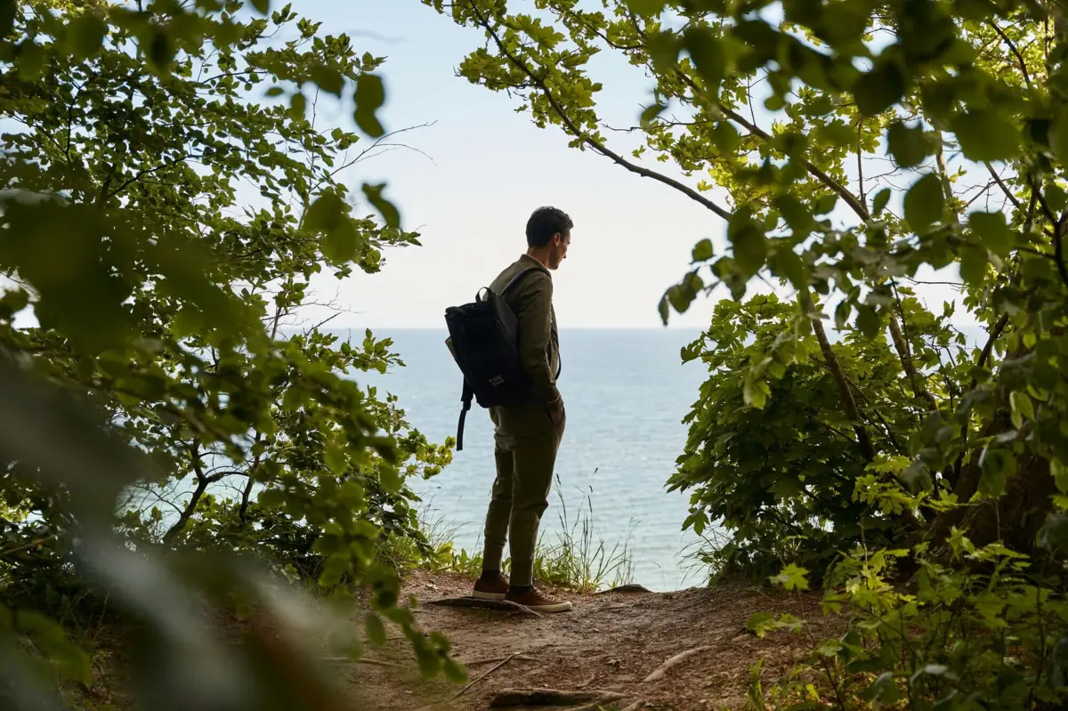 Wandern auf Rügen Ein Mann mit Rucksack steht auf einem Hügel.