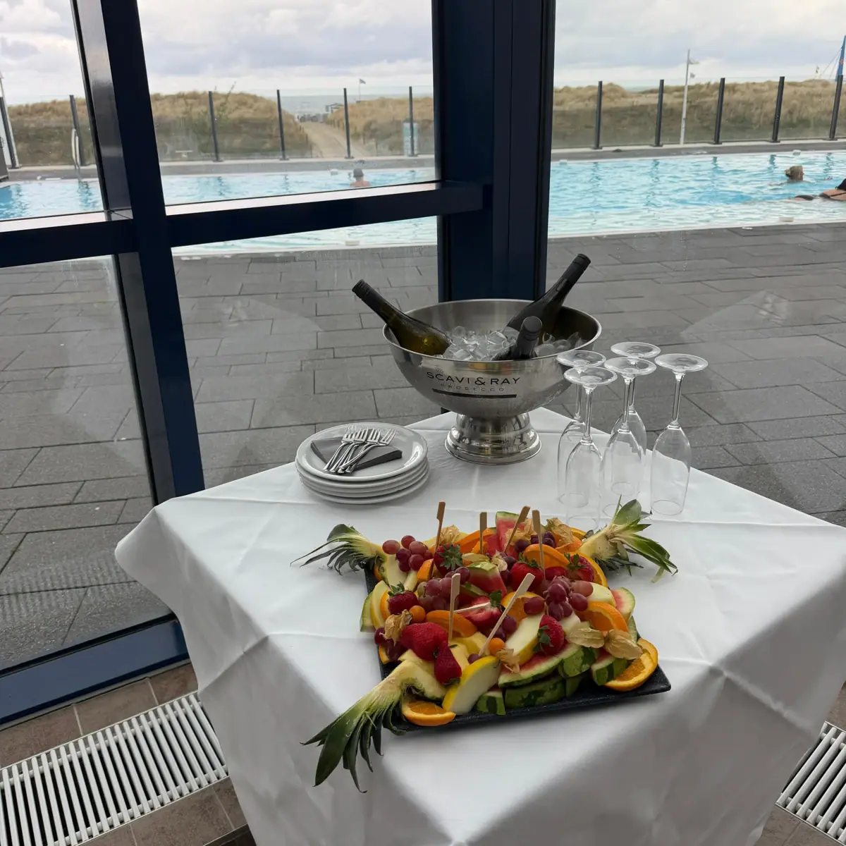 JGA Warnemünde Ein Tisch mit einer Schale Wein und Obst darauf.