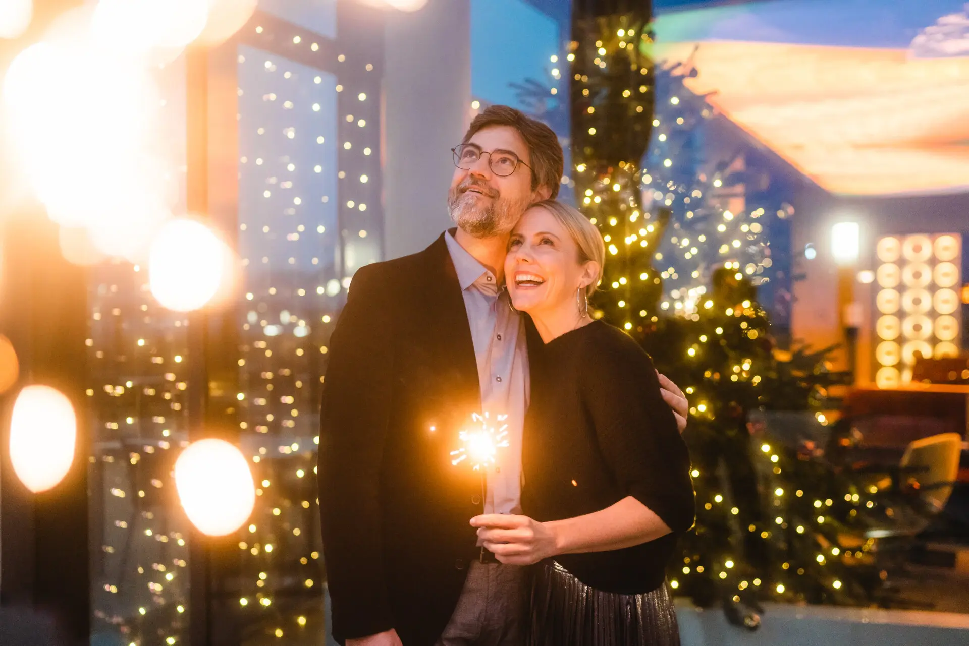 Silvester Ein Mann und eine Frau, die Wunderkerzen halten und in den Himmel gucken.