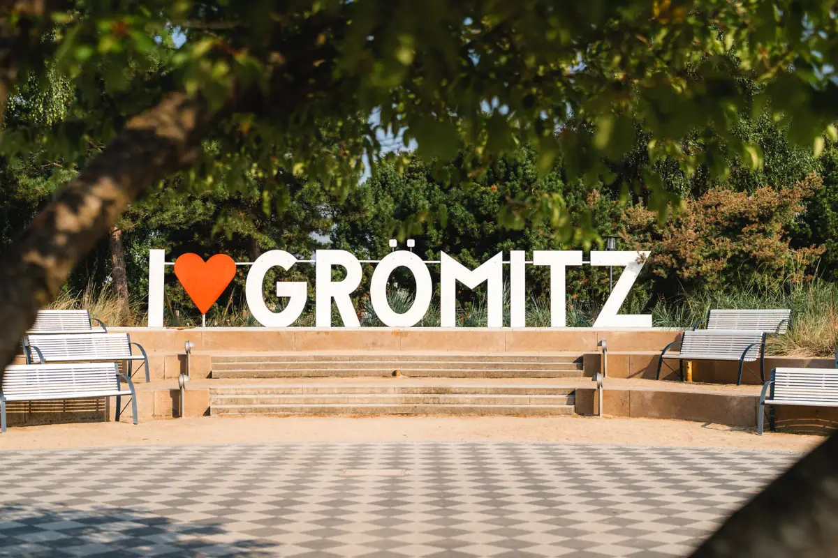 I love Grömitz Ein Schild mit "I love Grömitz" auf einer Treppe im Freien.