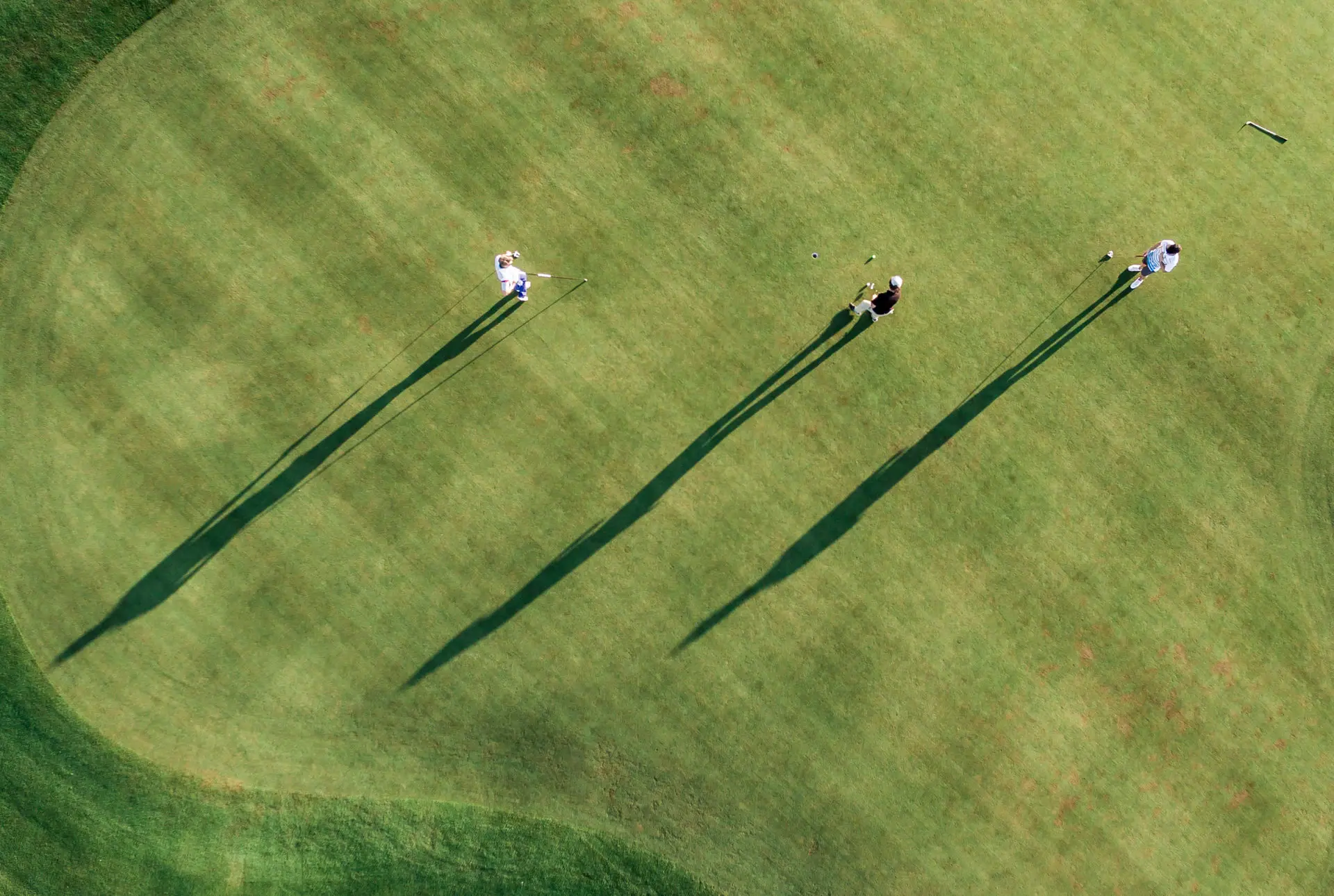Golfurlaub Eine Gruppe von Menschen spielt Golf auf einem Rasen.