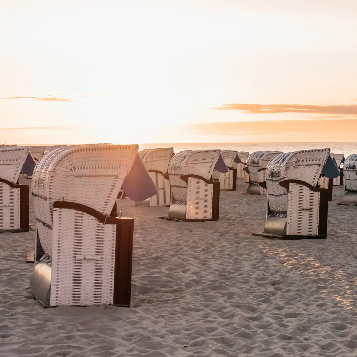 Strandkörbe in Grömitz Eine Gruppe von Strandstühlen am Strand.
