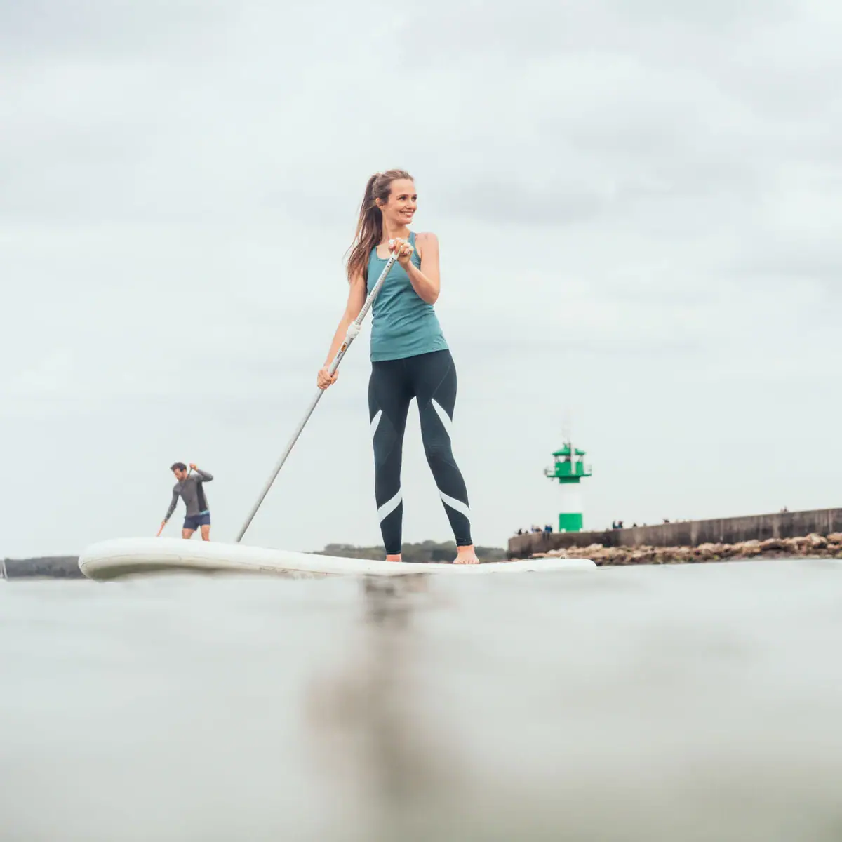 SUP auf der Ostsee Eine Frau und ein Mann auf einem Surfbrett auf dem Wasser.