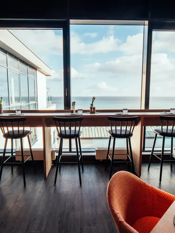 Blick aus dem Restaurant Ein Raum mit einem langen Tisch und Stühlen.