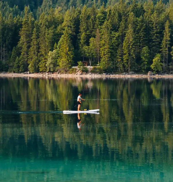 SUP Eibsee Ein Mensch auf dem Eibsee mit einem stand up paddle board