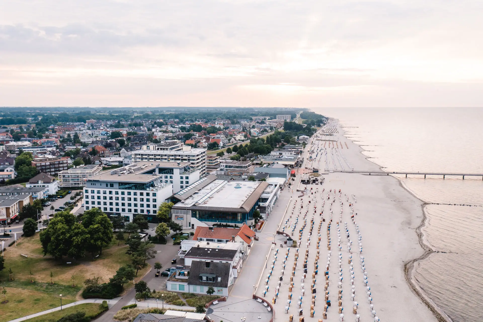 aja Grömitz Strandlandschaft mit vielen Strandkörben und an die Promenade grenzenden Gebäuden im Hintergrund