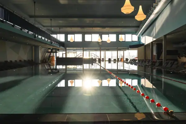 Schwimmbecken mit einer Reihe von Stühlen und einer Leiter im Innenbereich.