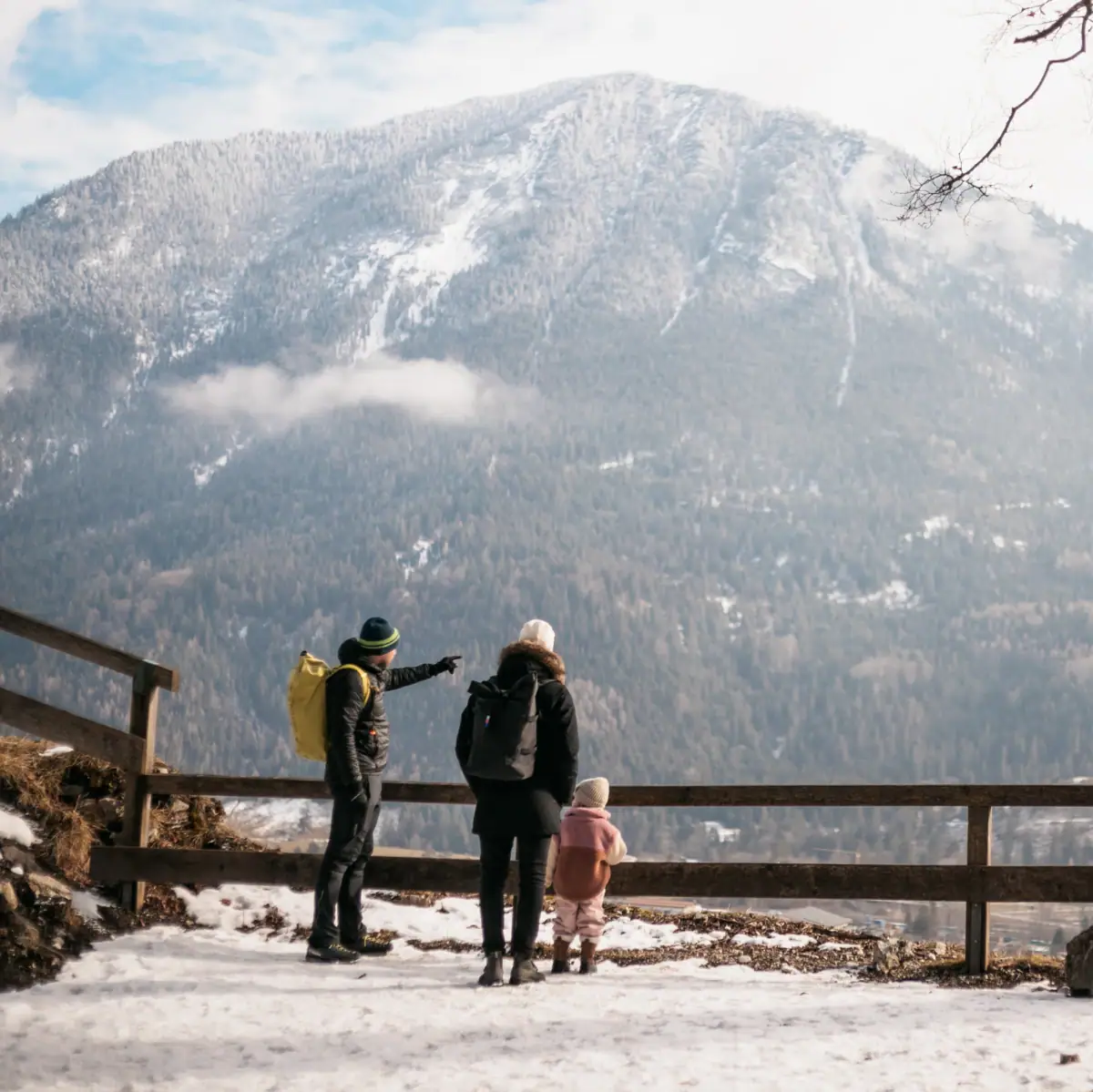 Winter in Garmisch-Partenkirchen Eine Gruppe von Menschen steht auf einem verschneiten Hügel mit Blick auf ein Bergpanorama.
