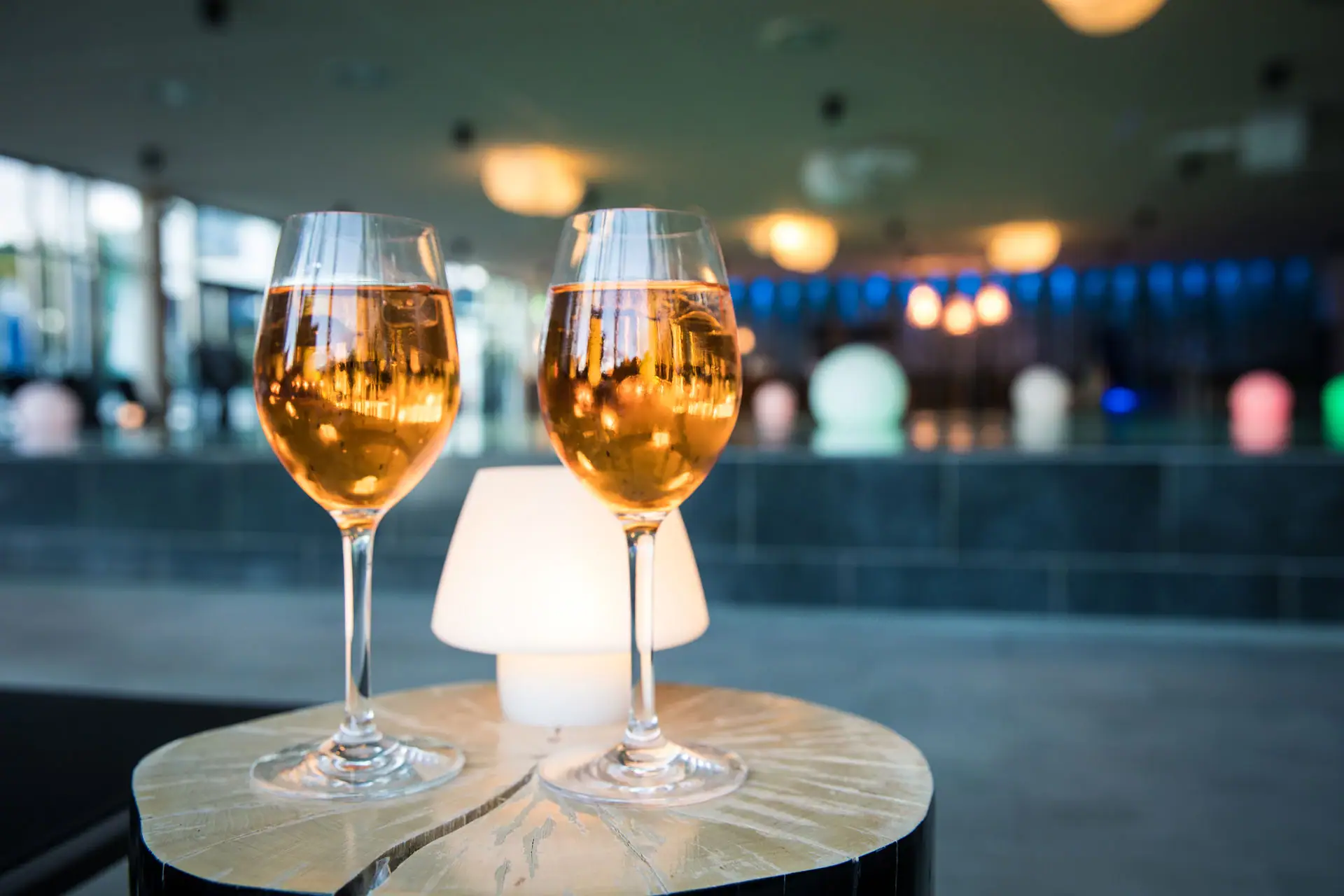 Poolbar im aja Bad Saarow Zwei Weingläser auf einem Tisch.