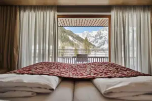 Bett Bergblick Ein Bett mit Blick auf die Berge durch ein Fenster.