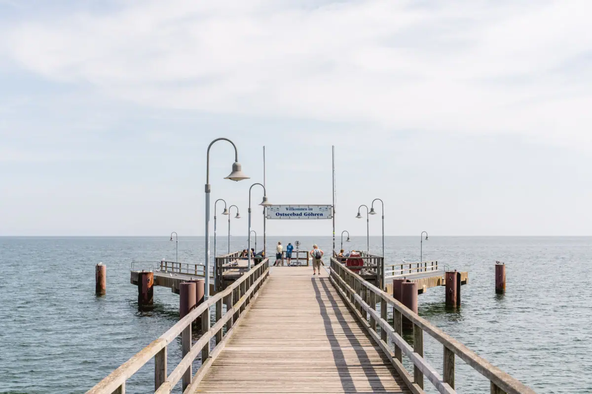 Seebrücke Sellin Holzsteg mit Menschen, die darauf spazieren gehen.