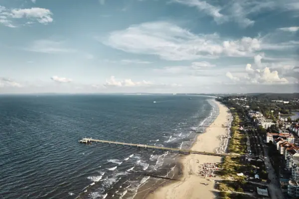 Langer Pier am Strand mit Blick auf das Meer und den Himmel.