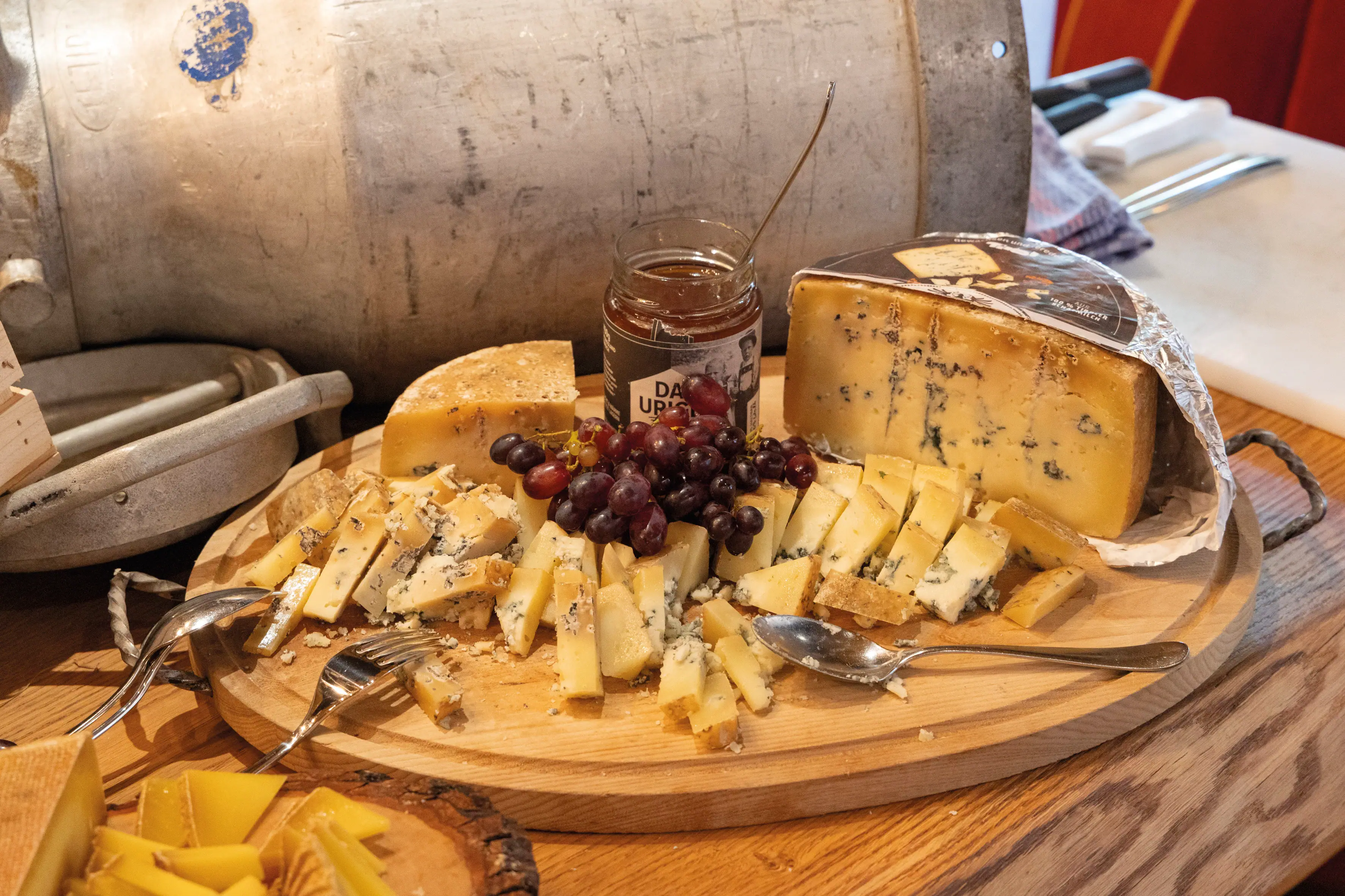 Käse Ein Teller mit Käse und Trauben.