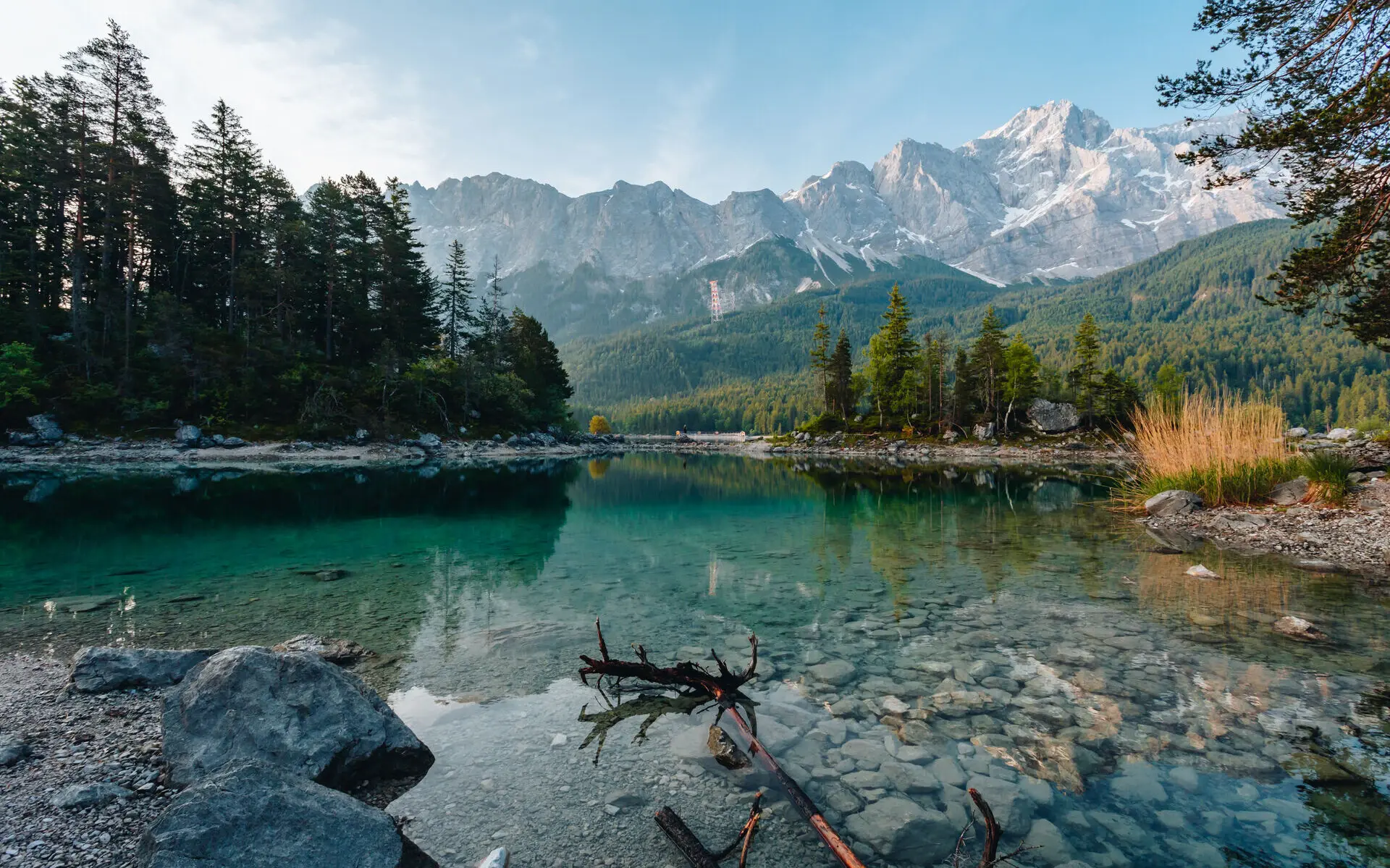 Eibsee Der kristallklare Eibsee vom Ufer fotografiert mit einer Gebirgskette im Hintergrund.