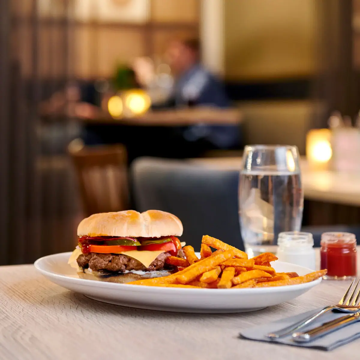 aja Bar in Warnemünde Ein Teller mit Burger und Pommes auf einem Tisch.