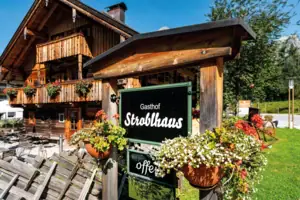Stroblhaus Ein Schild an einem Holzpfosten im Freien.