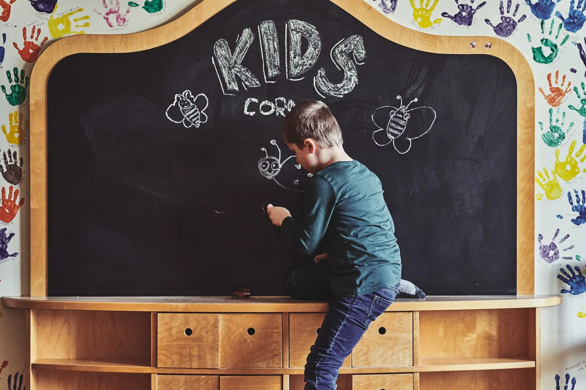 Kinderclub im aja Bansin Ein Junge schreibt an einer Wandtafel.