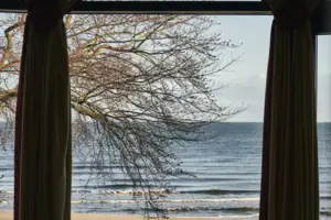 Ausblick aja Strandhotel Bansin Fenster mit Vorhängen und Blick auf den Strand