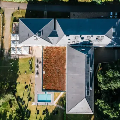 aja Bad Saarow Ein Gebäude mit Pool und Rasen im Freien.