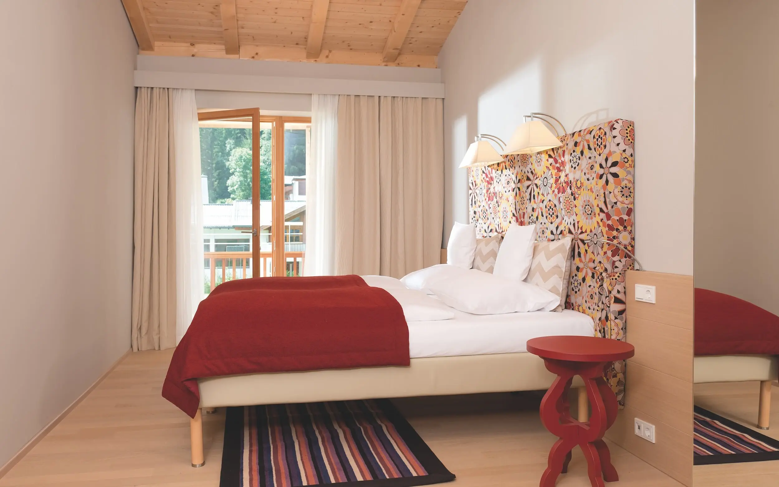 Schlafzimmer Ferienwohnung Werfenweng Ein Bett mit einem farbenfrohen Kopfteil in einem Zimmer.