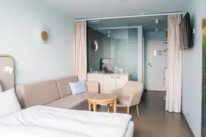 Doppelzimmer Ein Zimmer mit einem Sofa und einem Tisch.