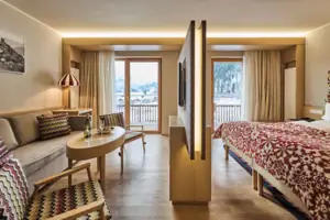 Juniorsuite Ein Zimmer mit einem Bett, einem Tisch und Stühlen.