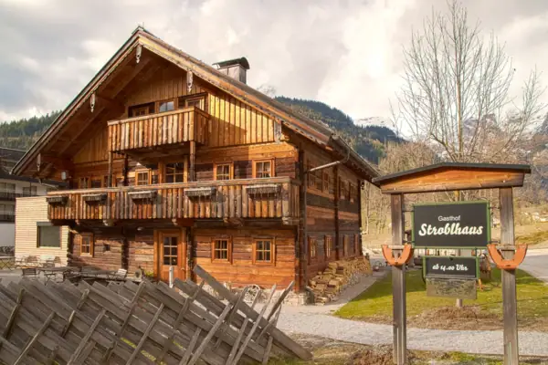 Stroblhaus Werfenweng Ein Holzhaus mit einem Schild davor.