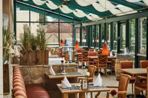 Innenansicht eines Restaurants mit Tischen und Stühlen.