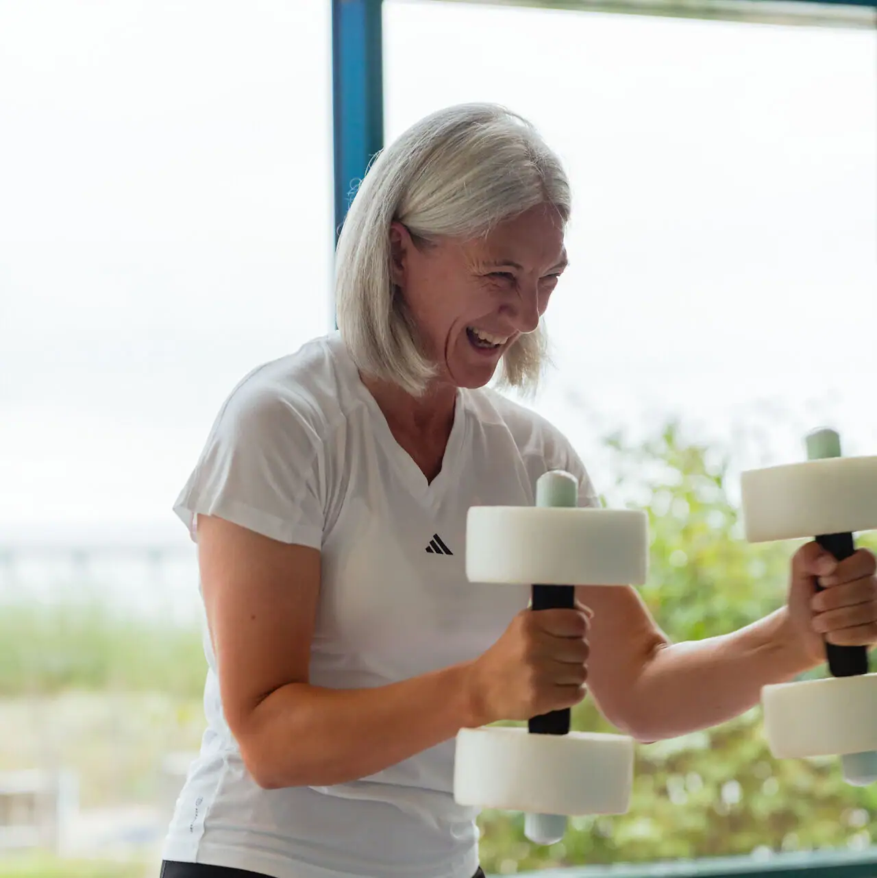 Aqua Fitness Eine Frau hebt Gewichte im Fitnessstudio.