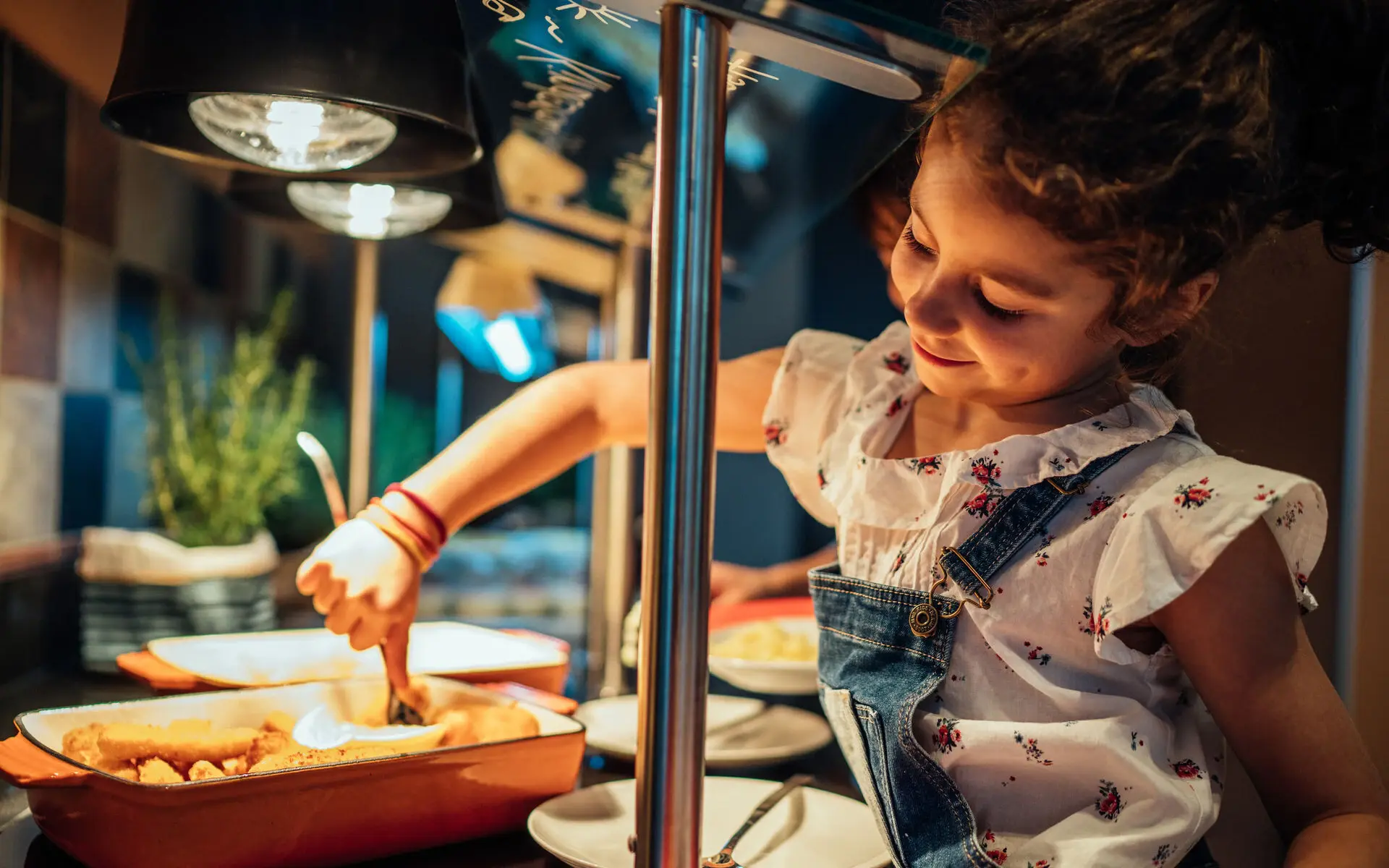 Kinderbuffet Ein Mädchen bedient sich am Kinderbuffet