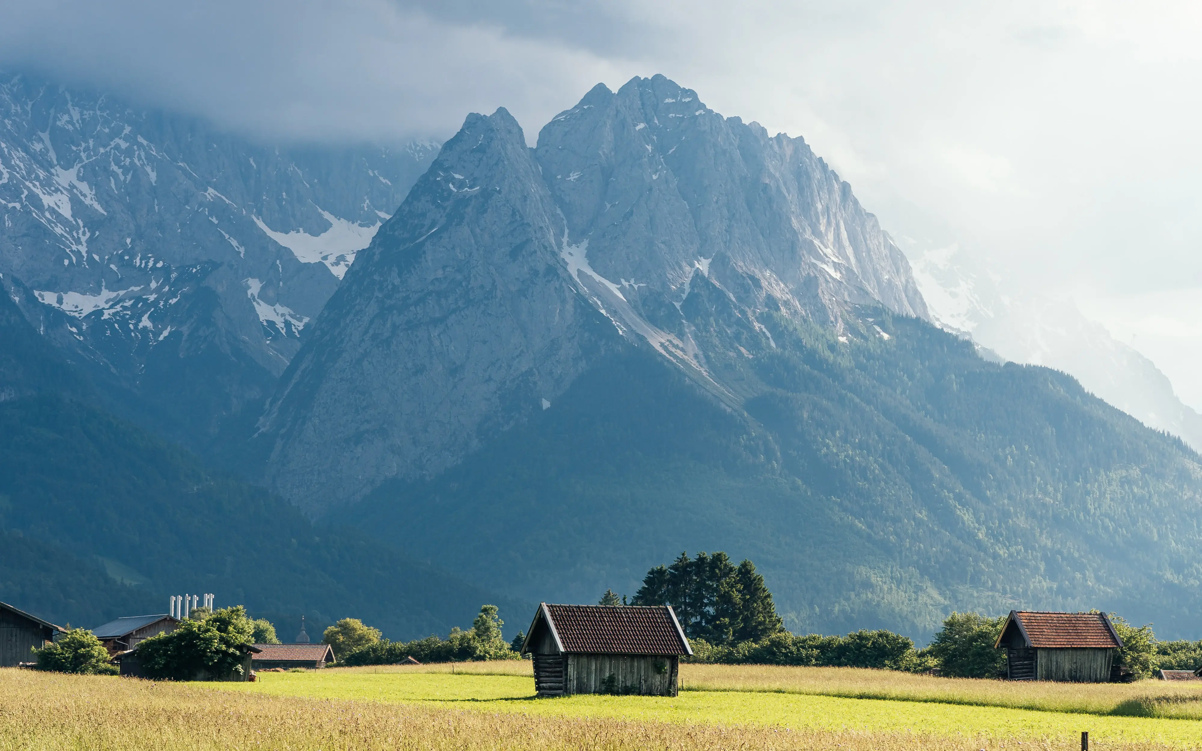 Holzhütte in einem Feld mit Bergen im Hintergrund