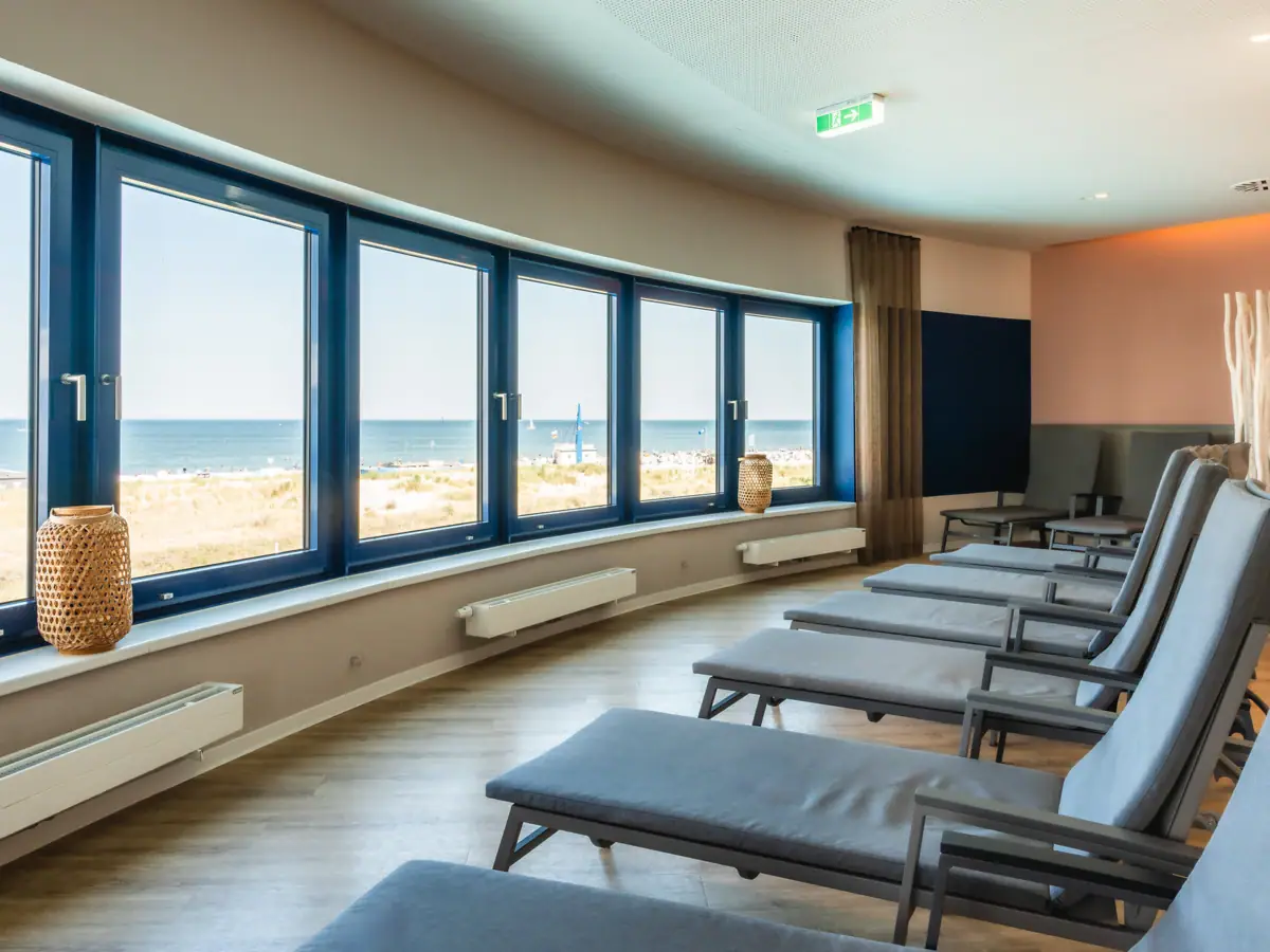 Ruhebereich im aja Warnemünde Ein Raum mit Stühlen und Fenstern, gestaltet im modernen Innendesign. Mit Ausblick Richtung Ostsee.