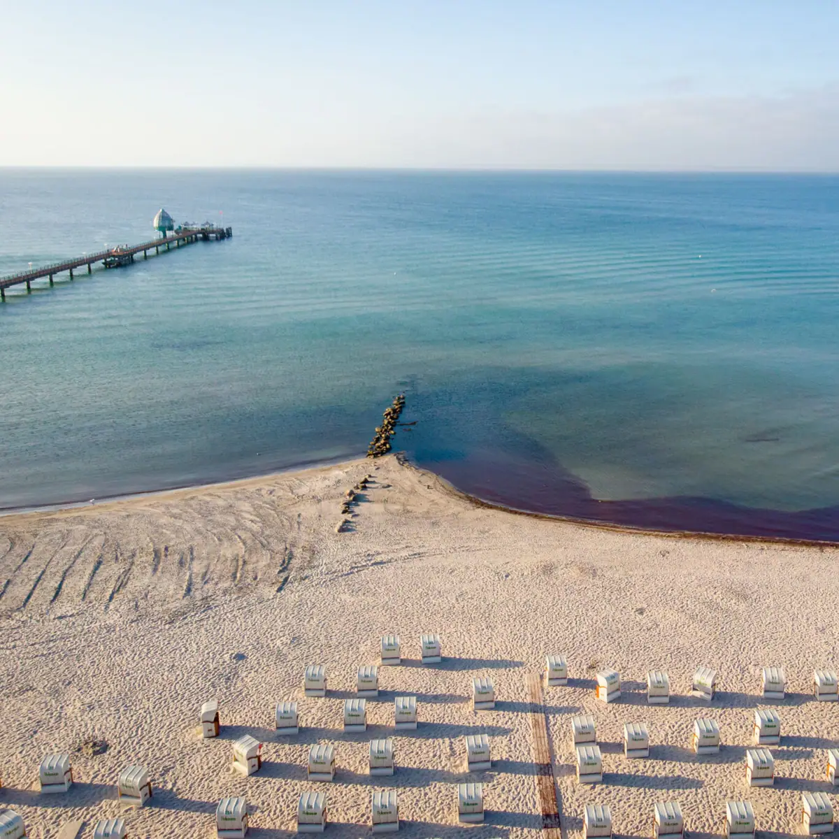 Strand von Grömitz mit Strandkörben und der Seebrücke.