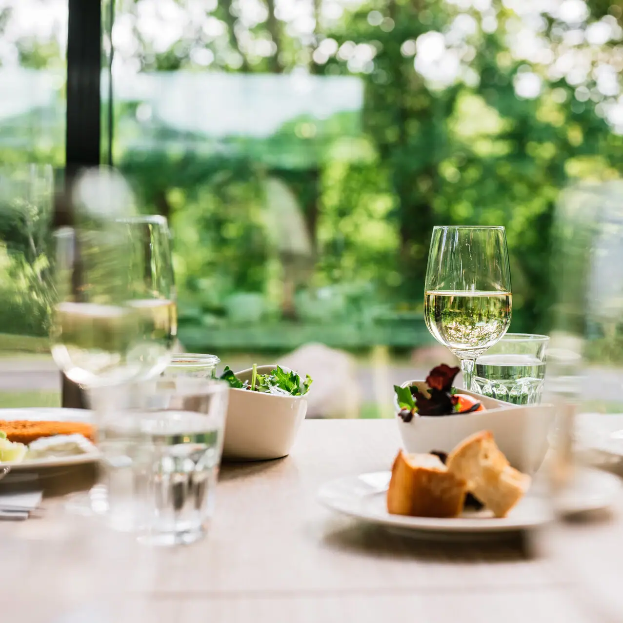 Essen und Trinken im aja Bad Saarow Ein Tisch mit verschiedenen Speisen und Weingläsern.