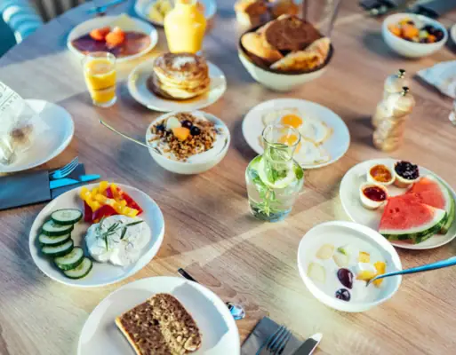 Frühstück Ein Tisch mit Tellern voller Speisen und Getränken.