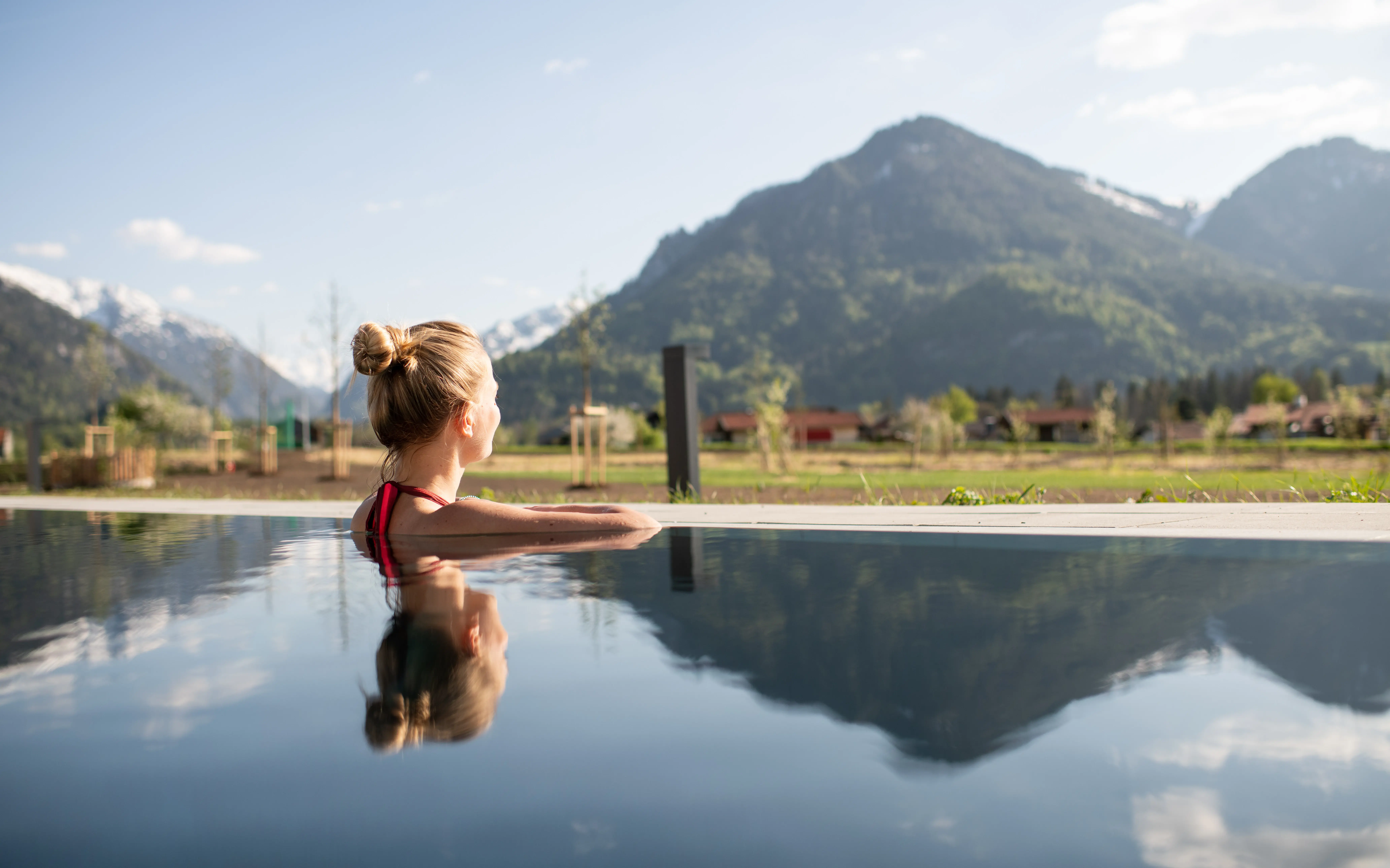 Frau im Außenpool mit Blick auf die Berge
