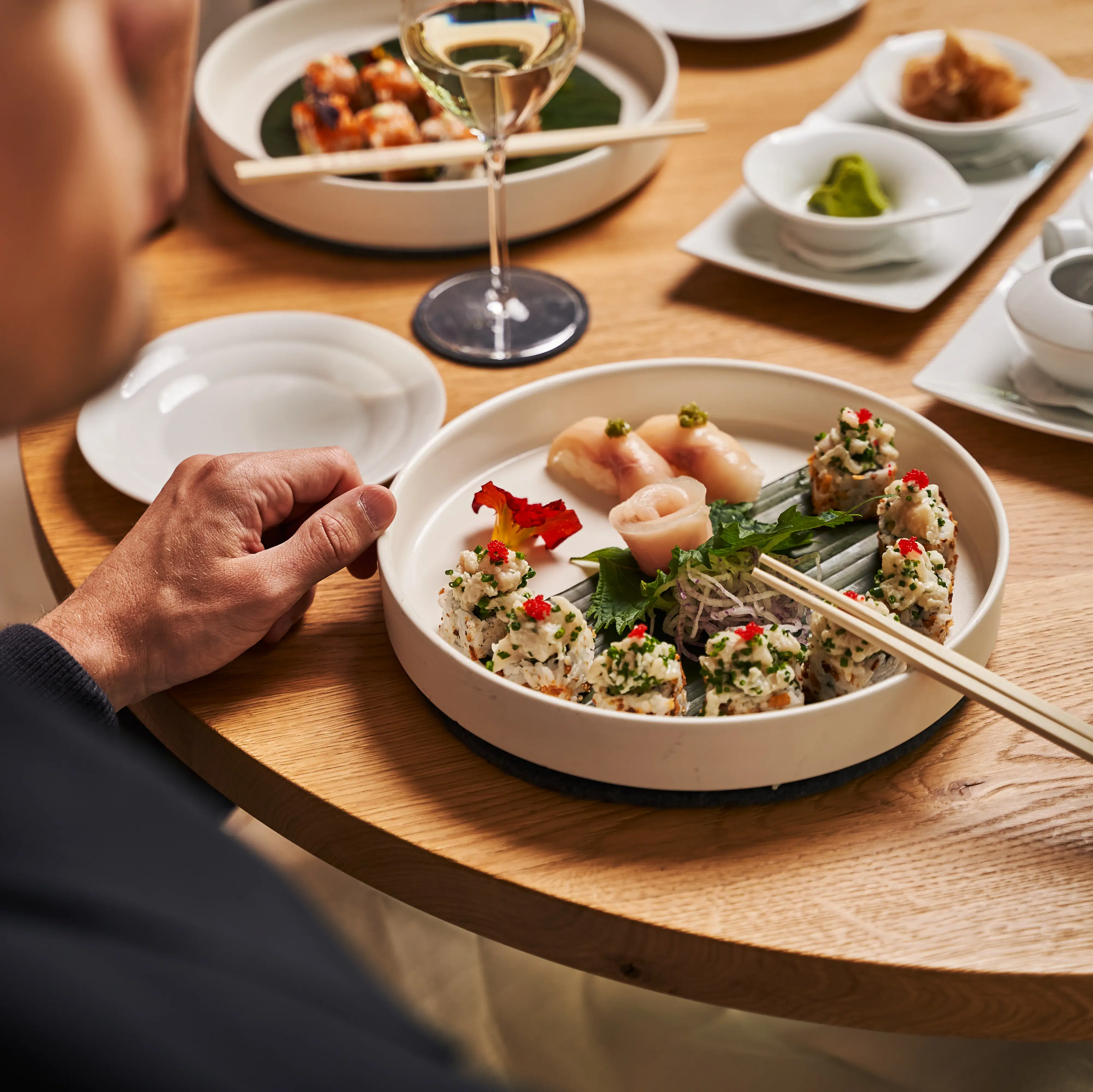 Sushi Eine Person isst an einem Tisch.