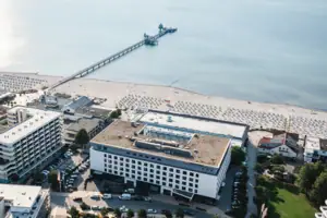 aja Grömitz Luftaufnahme eines Strandes mit angrenzenden Gebäuden.