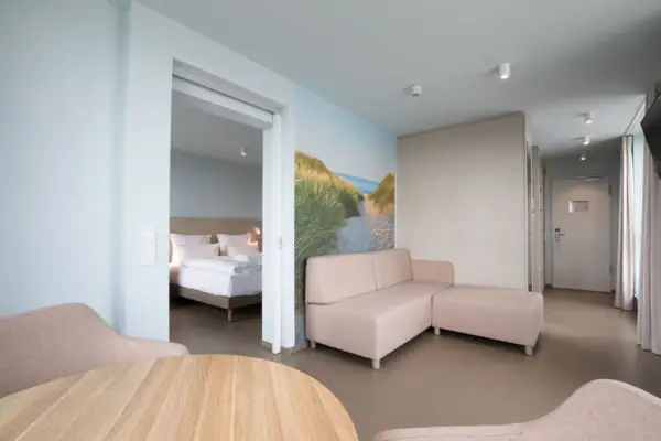 Suite im aja Travemünde Ein Zimmer mit einer Couch und einem Bett.