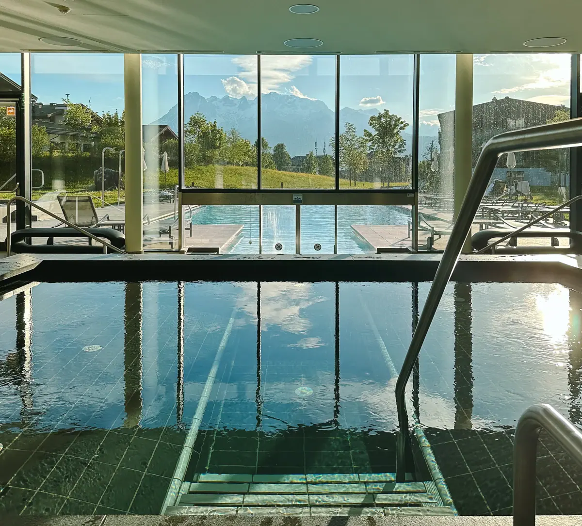 Pool aja Bergresort Werfenweng Der Poolbereich im aja Bergresort Werfenweng mit Innen und Außenpool und Bergen im Hintergrund.